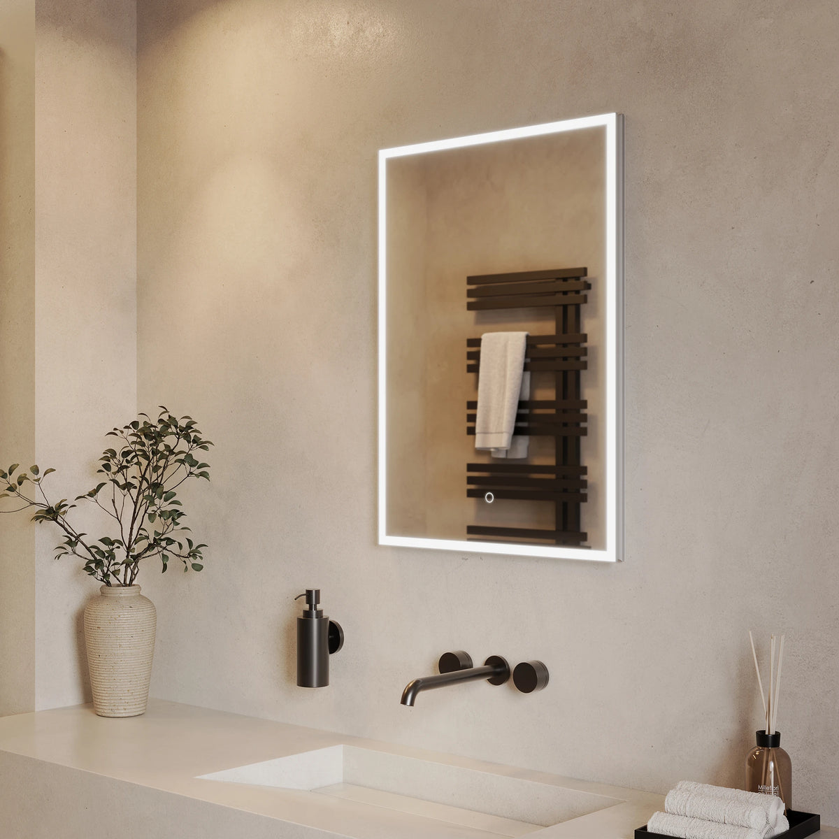 A modern rectangular LED-backlit bathroom mirror mounted on a textured beige wall above a white sink. The mirror reflects a dark wood heated towel rail with a white towel. #Size_500mm x 700mm