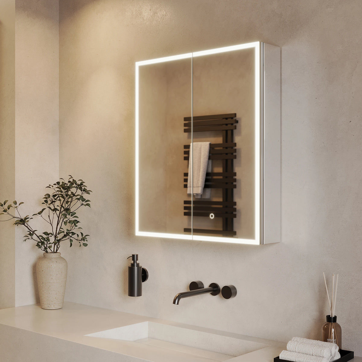 A modern wall-mounted medicine cabinet with an illuminated LED light frame, shown in a bathroom setting with a countertop, sink, soap dispenser, and decorative plant. #Size_600mm x 700mm